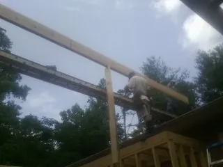 Carpenter setting a ridge beam over a new addition frame — Ice Dam Removal by Roofing Brothers in Varysburg