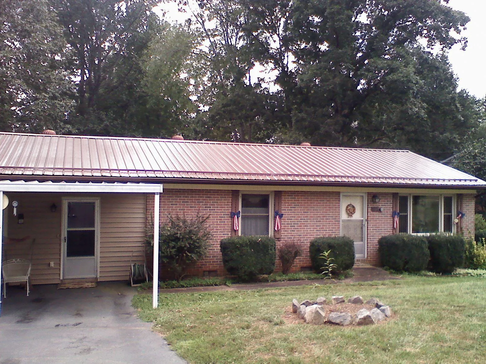 Bronze metal roof and carport on a brick ranch home — Roof Repair work by our crew in Varysburg